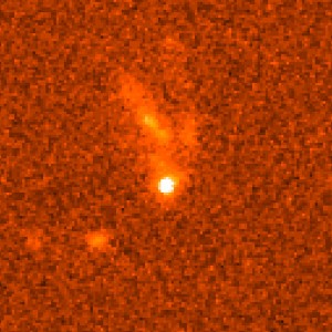 Sursaut Gamma GRB990123 (Gamma Ray Burst), photographié par Hubble le 8 février 1999. L'explosion ayant eu lieu le 23 janvier 1999, sa lueur sur cette photo ne représentait plus qu'un quatre millionième de ce qu'elle avait été. Soit aussi lumineuse que 100 millions de milliards d'étoiles ! Elle se situe au sein d'une galaxie se trouvant aux 2/3 de la distance qui nous sépare de l'horizon observable de l'univers. (Crédits: ESA/NASA)